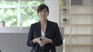 Picture of a woman. She has short hair and is wearing a dark blazer.